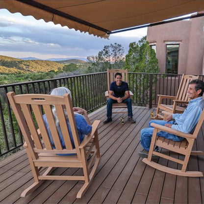 A013 Retractable Awning and Three people sitting on wooden rocking chairs on a deck with a scenic view of mountains and trees.