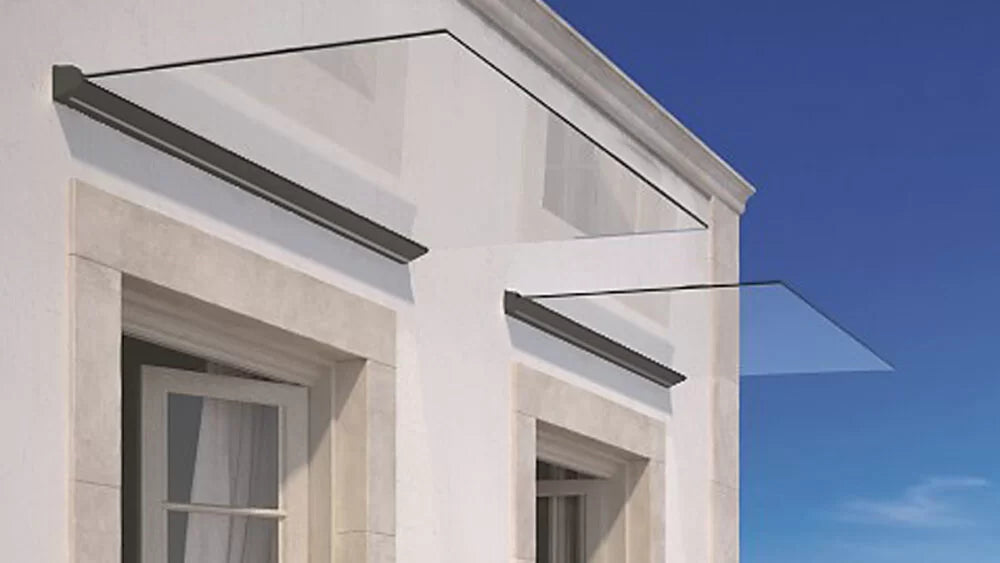 Glass canopy attached to a building with a clear blue sky background