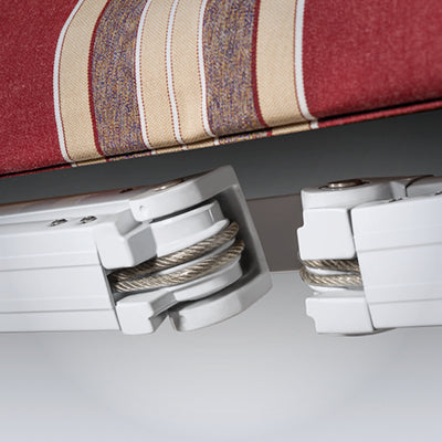Close-up of a striped fabric seat with white metal brackets on a gray surface.